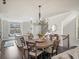 Dining area adjacent to the kitchen, featuring a modern chandelier and access to stairs at 3862 Firewood Ln # 110, Suwanee, GA 30024