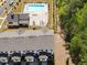 Aerial view of a pool with a fire pit, lounge chairs, tables, nearby landscaping and trees next to townhomes at 3862 Firewood Ln # 110, Suwanee, GA 30024