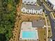 Aerial view of a pool with a fire pit, lounge chairs, tables, landscaping, trees and townhomes at 3862 Firewood Ln # 110, Suwanee, GA 30024