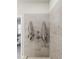 Neutral-toned tiled shower with modern fixtures and a glimpse into the bathroom at 3862 Firewood Ln # 110, Suwanee, GA 30024