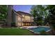 Lush backyard featuring a sparkling pool, a cozy hot tub, and a stone fireplace at 770 Pine Leaf Ct, Alpharetta, GA 30022
