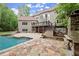Exterior of home with in-ground pool, outdoor fireplace, patio, deck and lush landscaping at 770 Pine Leaf Ct, Alpharetta, GA 30022