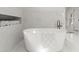 Modern white tub with marble tile surround and built-in storage for towels at 770 Pine Leaf Ct, Alpharetta, GA 30022