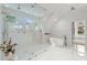 Bright bathroom featuring marble tile, soaking tub, a glass shower, and modern fixtures at 770 Pine Leaf Ct, Alpharetta, GA 30022
