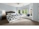 Large primary bedroom featuring many windows, a window seat, and a king bed at 770 Pine Leaf Ct, Alpharetta, GA 30022