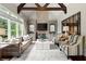 Spacious living room featuring a stone fireplace, vaulted ceilings with wooden beams, and a large decorative mirror at 770 Pine Leaf Ct, Alpharetta, GA 30022