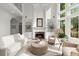 Living room featuring a fireplace, high ceilings, large windows, and neutral decor at 770 Pine Leaf Ct, Alpharetta, GA 30022