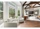 Bright living room features hardwood floors, vaulted ceilings with wooden beams, and large windows overlooking the green outdoors at 770 Pine Leaf Ct, Alpharetta, GA 30022