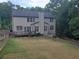 Two-story home's rear exterior with a deck, lawn, and wooded backdrop at 101 Brendylynn Trce, Woodstock, GA 30188