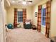 Well-lit bonus room features a ceiling fan, neutral carpet, and two windows dressed with colorful striped curtains at 101 Brendylynn Trce, Woodstock, GA 30188