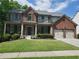 Charming brick home with a welcoming covered front porch, well-maintained landscaping, and an attached two-car garage at 101 Brendylynn Trce, Woodstock, GA 30188