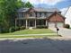 Inviting two-story home with a brick facade, covered porch, manicured lawn, and a two-car garage at 101 Brendylynn Trce, Woodstock, GA 30188