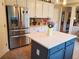 Eat-in kitchen with gray island, stainless steel appliances, tile floor, and white cabinets at 101 Brendylynn Trce, Woodstock, GA 30188