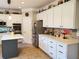 Bright eat-in kitchen with stainless steel appliances, white cabinets, gray island, and tile flooring at 101 Brendylynn Trce, Woodstock, GA 30188