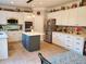 Spacious kitchen with stainless steel appliances, white cabinets, tile floor, and gray kitchen island at 101 Brendylynn Trce, Woodstock, GA 30188