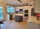 Open kitchen with white cabinets, stainless appliances, stone backsplash, and gray kitchen island at 101 Brendylynn Trce, Woodstock, GA 30188