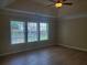 Bright bedroom with hardwood floors, ceiling fan, and large windows overlooking the backyard at 101 Brendylynn Trce, Woodstock, GA 30188