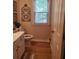 Well-lit powder room with wood-look floors, simple decor, and a window for fresh air at 101 Brendylynn Trce, Woodstock, GA 30188