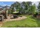 Lush backyard features a stone patio, outdoor dining area, mature trees, and a fenced perimeter at 2660 Pete Shaw Rd, Marietta, GA 30066
