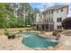 Expansive backyard with a stone patio and pool that has rock features, landscaping, and mature trees at 2660 Pete Shaw Rd, Marietta, GA 30066