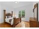 Cozy bedroom with wooden bed frame, hardwood flooring, and a large window at 2660 Pete Shaw Rd, Marietta, GA 30066