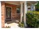 Charming front porch with brick details, elegant columns, a decorative wreath, and colorful flowers at 101 Magnolia Creek Dr, Canton, GA 30115