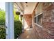 Inviting front porch with classic brickwork, white columns, hanging flower baskets and concrete flooring at 101 Magnolia Creek Dr, Canton, GA 30115