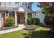 Inviting front porch with brick accents, decorative columns, and lush landscaping leading to the front door at 101 Magnolia Creek Dr, Canton, GA 30115