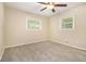 Cozy bedroom featuring neutral carpeting, a ceiling fan, and windows offering ample natural light at 2724 Quincy Ln, Decatur, GA 30034