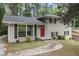 Charming home featuring a painted brick facade, complemented by a bright red front door and well-manicured landscaping at 2724 Quincy Ln, Decatur, GA 30034