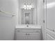 Well-lit bathroom vanity area with white cabinets, a large mirror, and updated lighting fixtures at 3460 Highgate Hills Ne Dr, Duluth, GA 30097