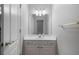 Well-lit bathroom vanity area with white cabinets, a large mirror, and updated lighting fixtures at 3460 Highgate Hills Ne Dr, Duluth, GA 30097
