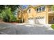 Two-story home showcasing the spacious driveway and three-car garage with lovely landscaping at 3460 Highgate Hills Ne Dr, Duluth, GA 30097
