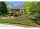 Charming yellow two-story home boasts a covered front porch and mature landscaping at 3460 Highgate Hills Ne Dr, Duluth, GA 30097