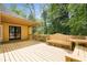 Outdoor patio featuring wood decking, a covered porch, and built-in bench seating overlooking a lush backyard at 3460 Highgate Hills Ne Dr, Duluth, GA 30097