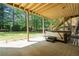Covered outdoor patio with a hot tub, wooden staircase, and views of the lush backyard at 3460 Highgate Hills Ne Dr, Duluth, GA 30097