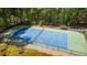 Aerial view of the private, fenced tennis court surrounded by lush greenery at 3460 Highgate Hills Ne Dr, Duluth, GA 30097