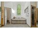 An opulent bathroom featuring a sunken tub, a stained glass window, and a glass enclosed shower at 4340 Candacraig, Johns Creek, GA 30022