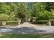 A long, stone driveway leads to an upscale home, surrounded by mature trees and manicured landscaping at 4340 Candacraig, Johns Creek, GA 30022