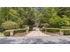Gated entrance with stone pillars and manicured hedges leading to a private estate at 4340 Candacraig, Johns Creek, GA 30022