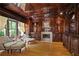 Elegant living room with rich wood paneling, fireplace, and large window with natural light at 4340 Candacraig, Johns Creek, GA 30022