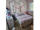 Bedroom with decorative vines and bed with a patterned comforter, great natural light from a nearby window at 908 Pine Oak Trl, Austell, GA 30168