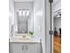 Cozy bathroom with large mirror, decorative light fixture, white vanity, and view into adjacent room at 2324 Towneheights Se Ter # 11, Atlanta, GA 30339