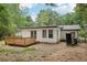 Home featuring a charming backyard with a small wooden deck and a spacious lawn, surrounded by mature trees at 2450 Elkhorn Dr, Decatur, GA 30034