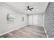 Stylish living room features modern ceiling fan, two windows, and a painted brick accent wall at 2450 Elkhorn Dr, Decatur, GA 30034