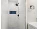 Shower featuring white tile, black fixtures, and a unique mosaic tile accent at 2450 Elkhorn Dr, Decatur, GA 30034