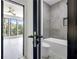 Bathroom door open to a bedroom, the bath and shower are modern and gray at 191 Darwish Dr, Mcdonough, GA 30252