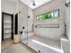 Bright, modern bathroom with a glass shower enclosure, linear window, and gray tile at 191 Darwish Dr, Mcdonough, GA 30252