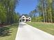 Long driveway leading to a two-story modern home surrounded by mature trees on a spacious lot at 191 Darwish Dr, Mcdonough, GA 30252