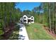 Expansive lawn leads up to a modern home with lots of windows and a long concrete driveway at 191 Darwish Dr, Mcdonough, GA 30252